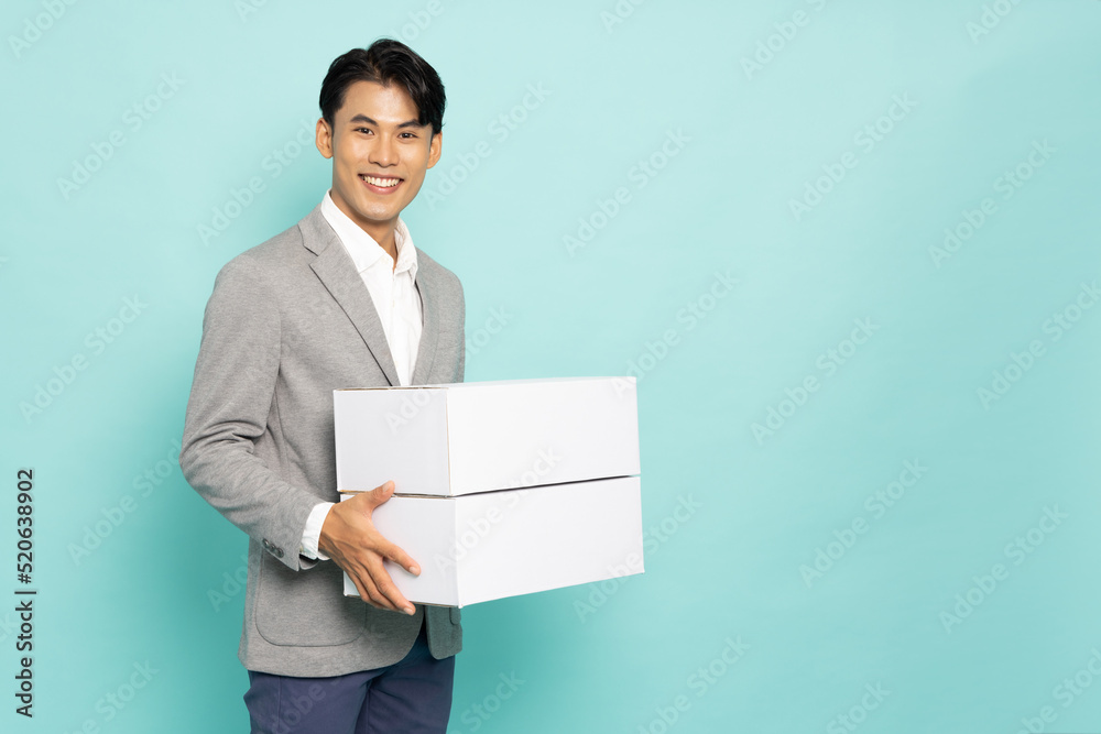 Asian businessman holding package parcel box isolated on green background, Delivery courier and shipping service concept Asian businessman holding package parcel box isolated on green background, Delivery courier and shipping service concept