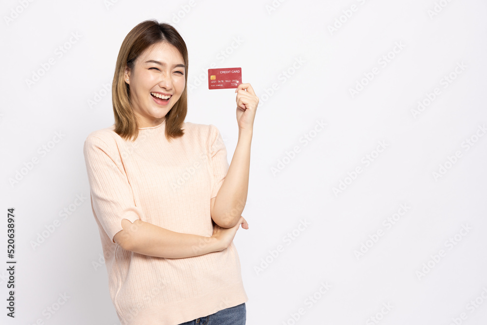 Happy young Asian woman smiling and showing red credit card for paying online business isolated on white background Happy young Asian woman smiling and showing red credit card for paying online business isolated on white background