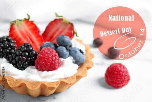 National Dessert Day, October 14. Tasty tartlet with different fresh berries on white marble table, closeup