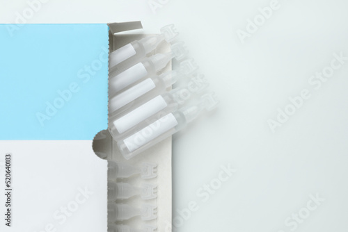 Package with single dose ampoules of sterile isotonic sea water solution on white background, top view. Space for text