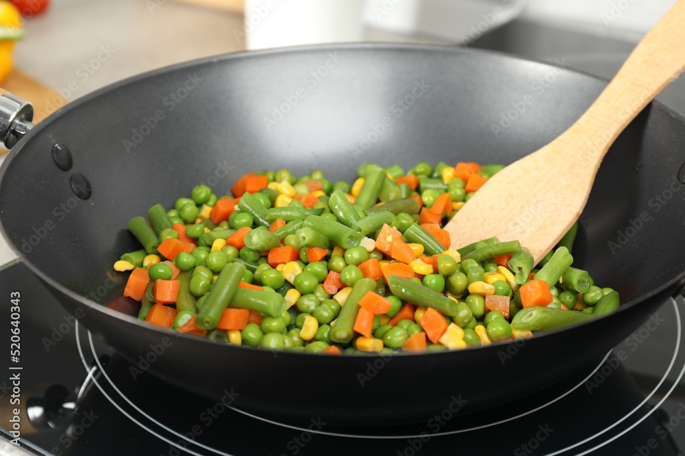 Cooking tasty vegetable mix in wok pan, closeup