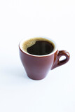Black coffee in the brown cup on the white  background. Closeup. Location vertical.