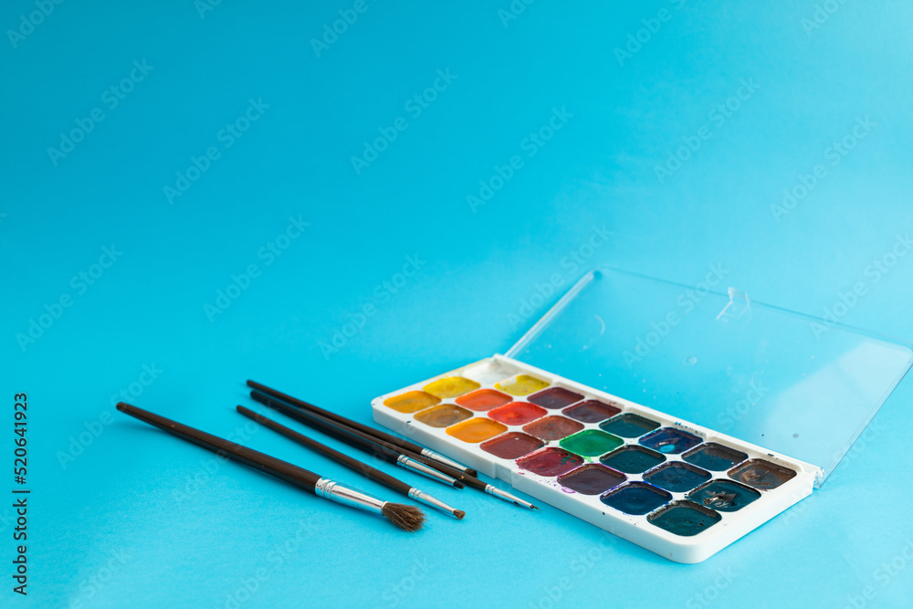 Brushes, painting tools and paints on a blue background Brushes, painting tools and paints on a blue background