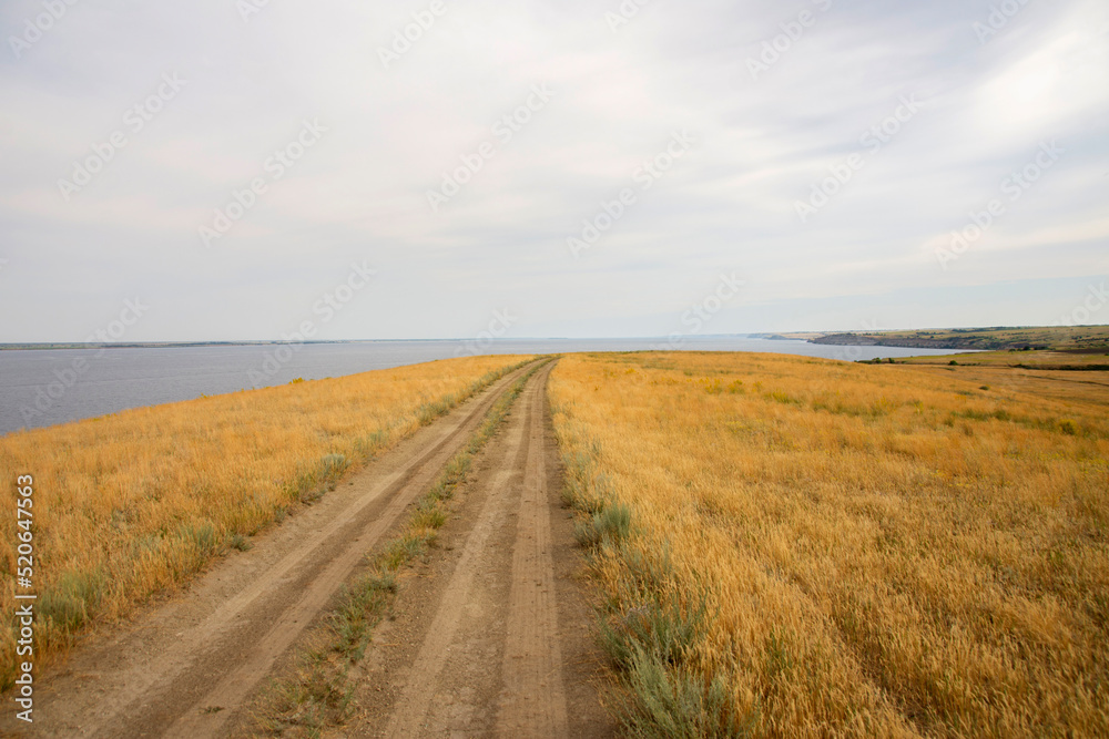 dirt road leading to the edge of a cliff above the water