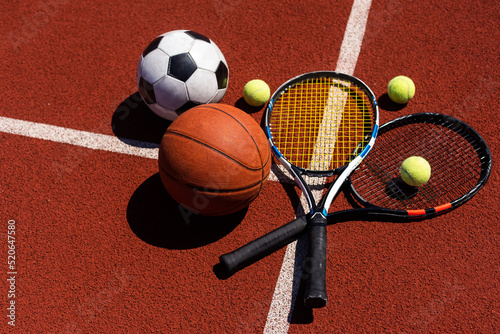 Sport games equipment - balls, rackets - on court.