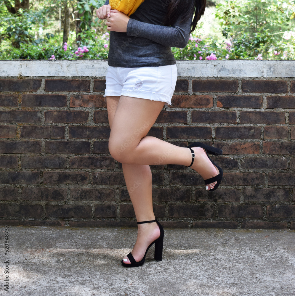 Mujer modelando zapatos de tacon negros, mujer latina con bonitas piernas y  pantalon corto. Stock Photo