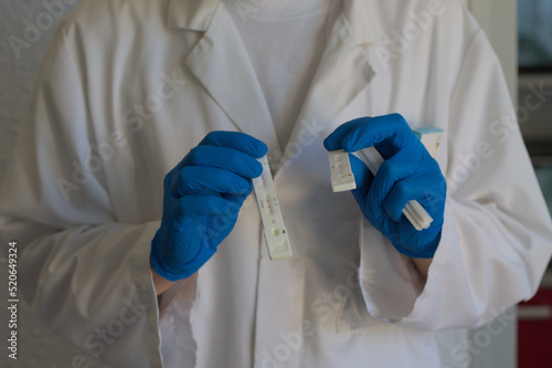 médecin en blouse avec des gants bleus montrant des autotests covid-19 (sars cov2) photo