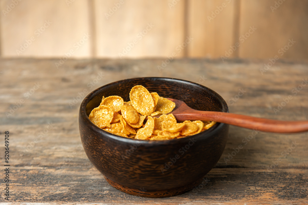 Cereal in wooden bowl with milk splash on blurred wooden Cereal in wooden bowl with milk splash on blurred wooden
