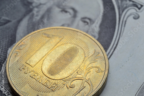 Russian coins of 10 rubles face value lie on the American, paper dollar.