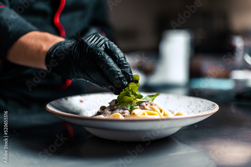 Fototapeta Naklejka Na Ścianę i Meble -  Close up chef serving food in the modern kitchen in a high-end restaurant