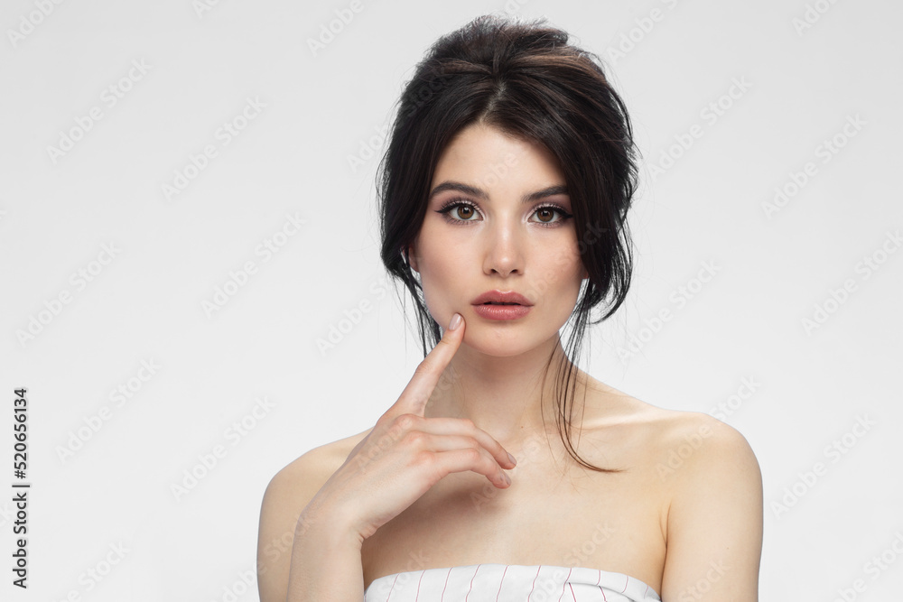 Front view of a cute brunette with bare shoulders with makeup, isolated white background. Front view of a cute brunette with bare shoulders with makeup, isolated white background.