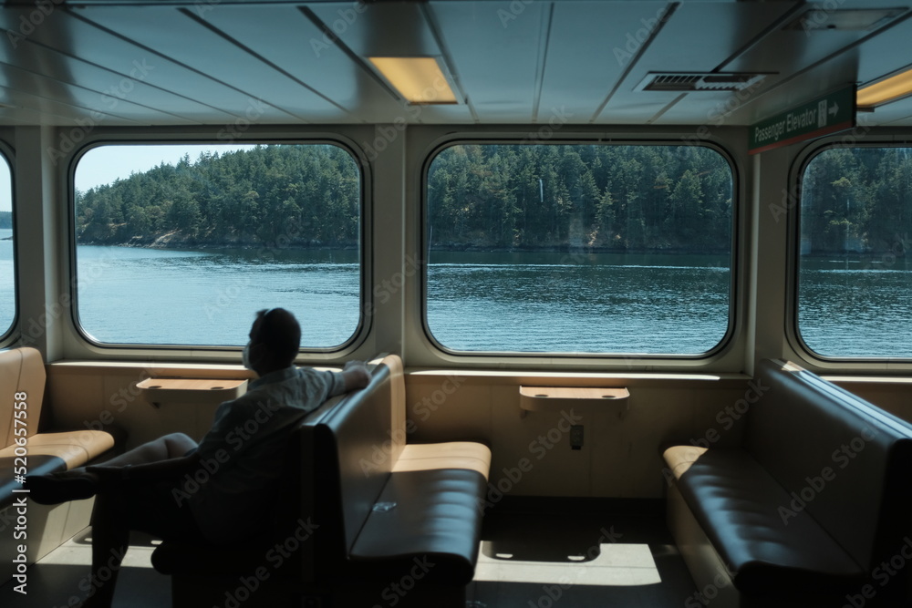 Man looking out boat window at island