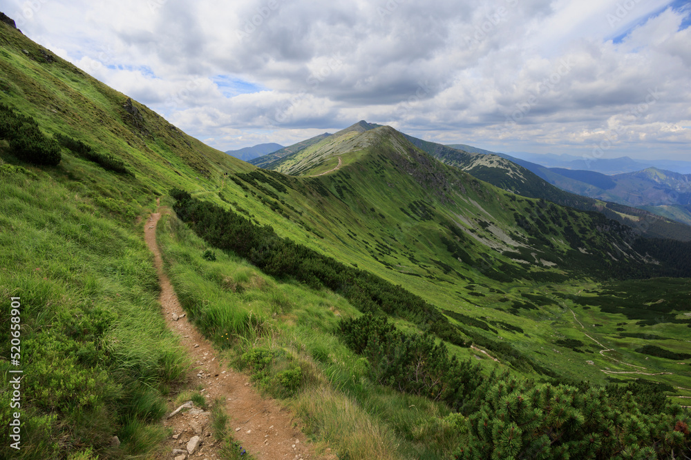 Konske, Chopok and Siroka dolina, Nizke Tatry, Low Tatras, Slovakia, Europe - beautiful nature and landscape with mountains and valley. Cloudy summer with green grass. Wide angle with soft corners.