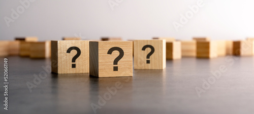 front view on many wood cubes with question marks. many question arising concept photo
