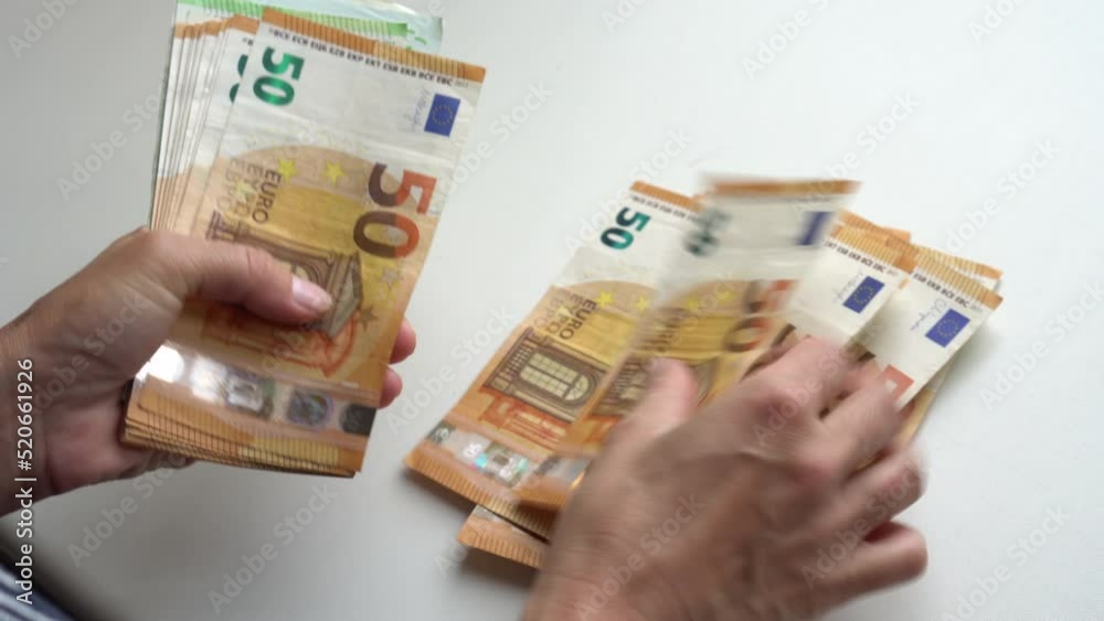 Female hand counting euro banknotes nominated 50.