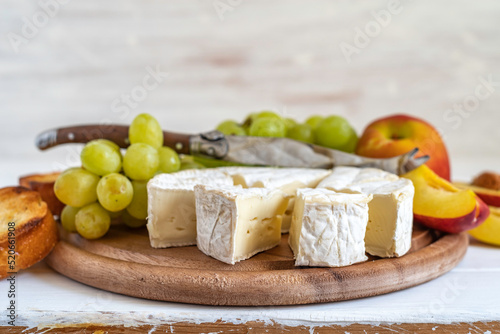 Brie cheese for Mediterranean breakfast on wooden background.
