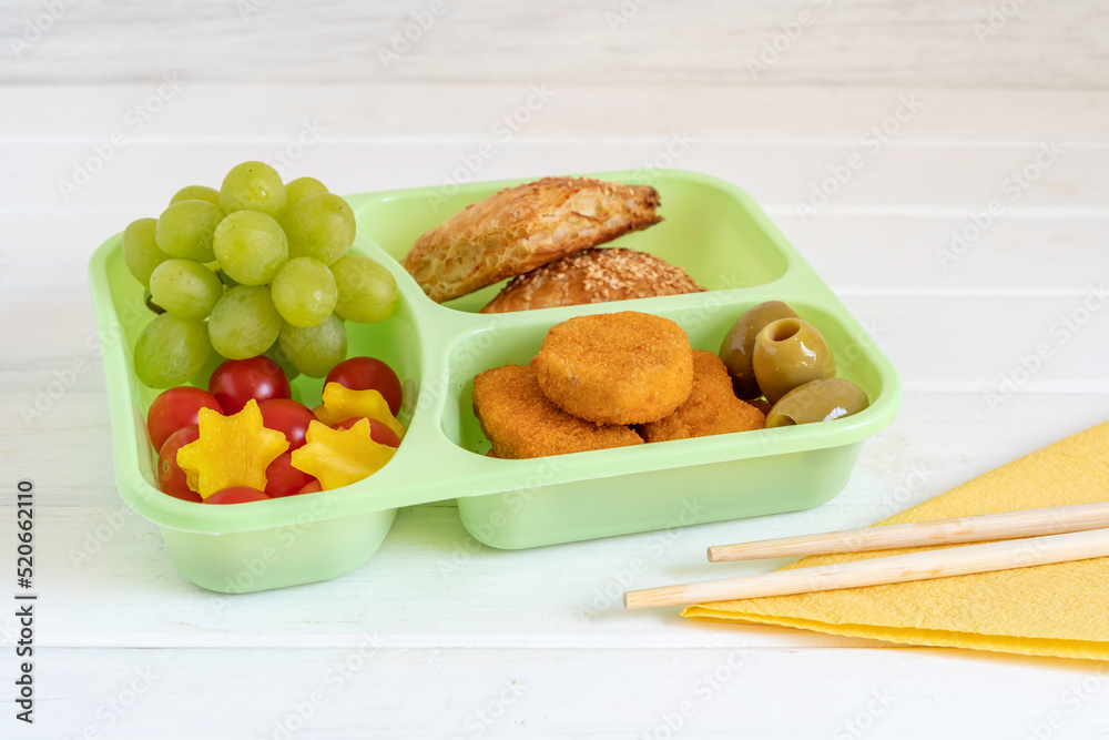 Lunch box with chicken nuggets, fresh fruits, olives, bread for kid's breakfast on white wooden background. Lunch box with chicken nuggets, fresh fruits, olives, bread for kid's breakfast on white wooden background.