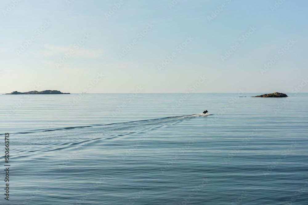 Small boat setting out to sea on a quiet and sunny morning.