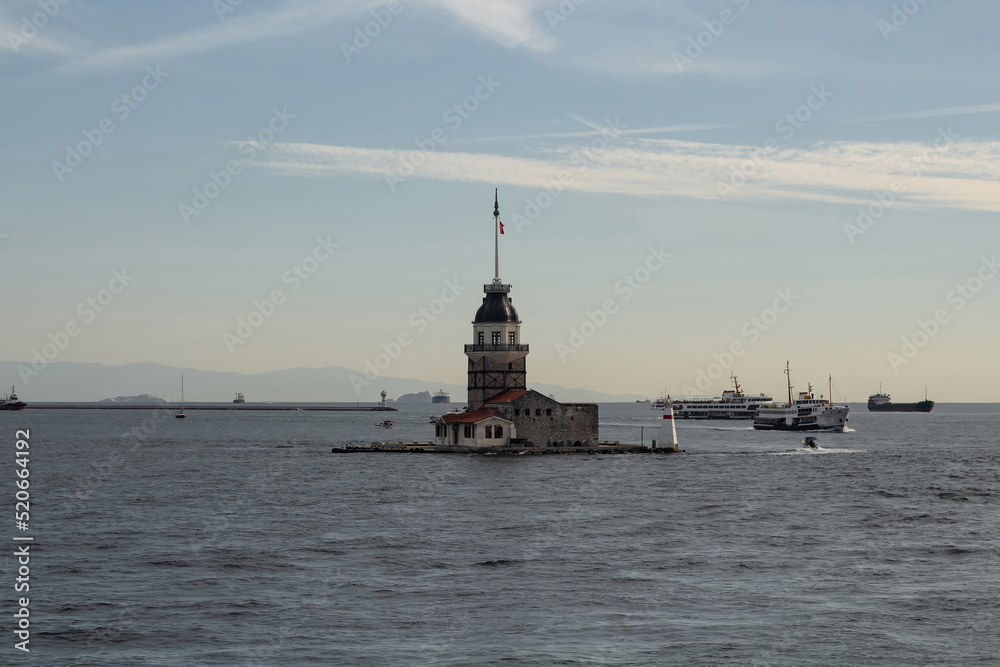 View of historical landmark called Maiden Tower and ferry boats on Bosphorus in Istanbul. Beautiful scene.