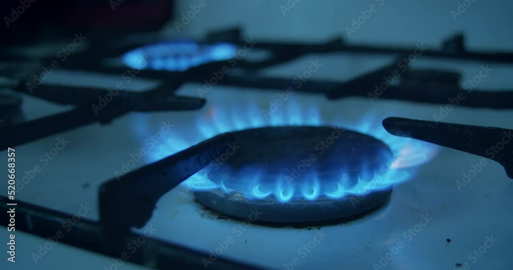 Natural Gas is burning in gas-stove in the kitchen. Concept of problems with natural gas in European union, rising gas prices.