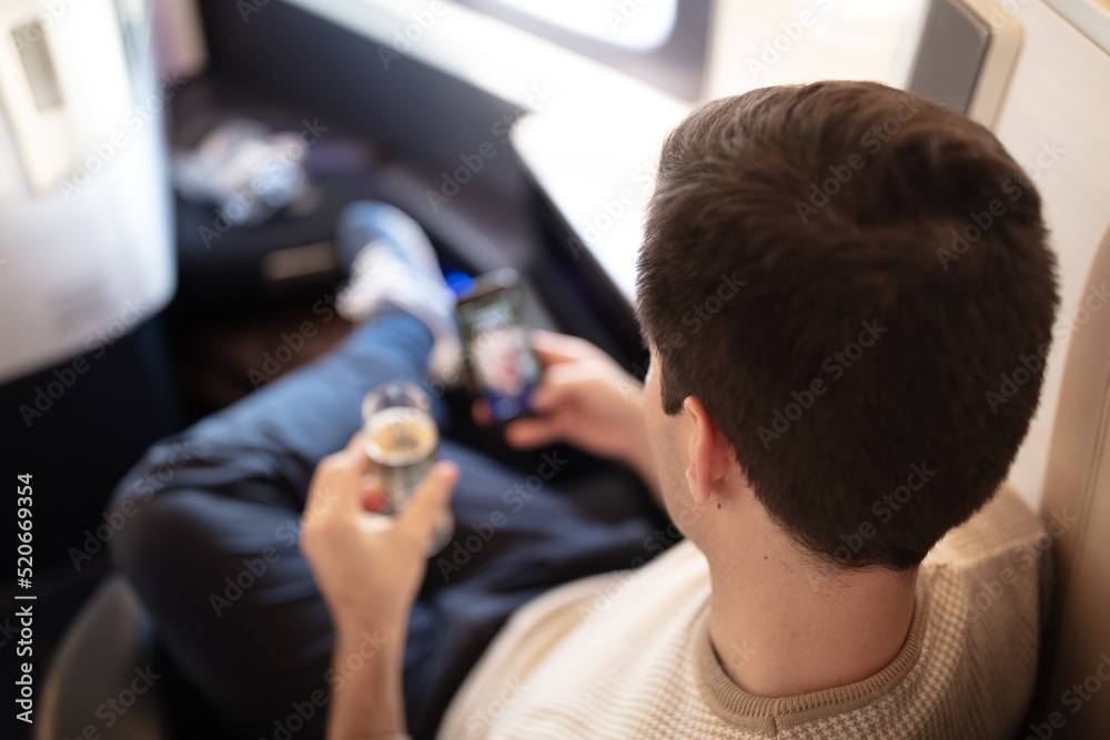 Business man in a suit and tie being pampered by flight attendants in first class. Business man in a suit and tie being pampered by flight attendants in first class.