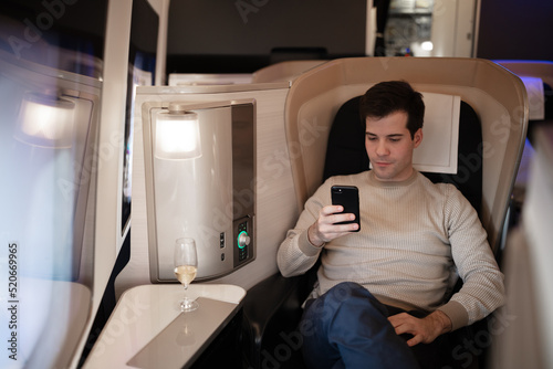 Rich businessman flying first class and working on plane