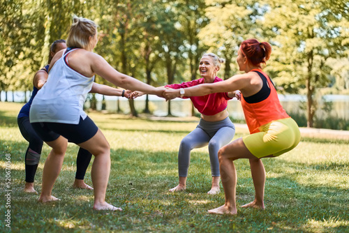Wallpaper Mural Group of women exercising together during outdoor fitness class in park
