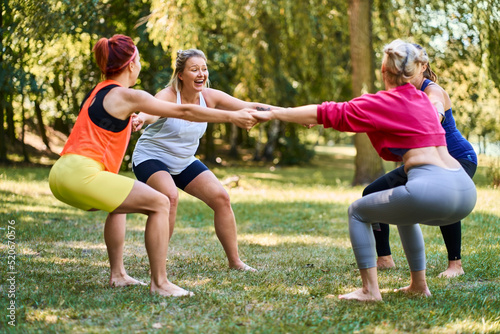 Group of women enjoying exercising together during outdoor fitness class in park