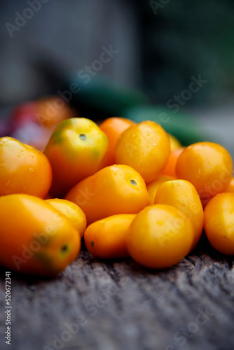 Fresh organic yellow tomatoes. Eco friendly non-gmo yellow tomatoes on the table. The concept of health, non-gmo products, clean ecological food.