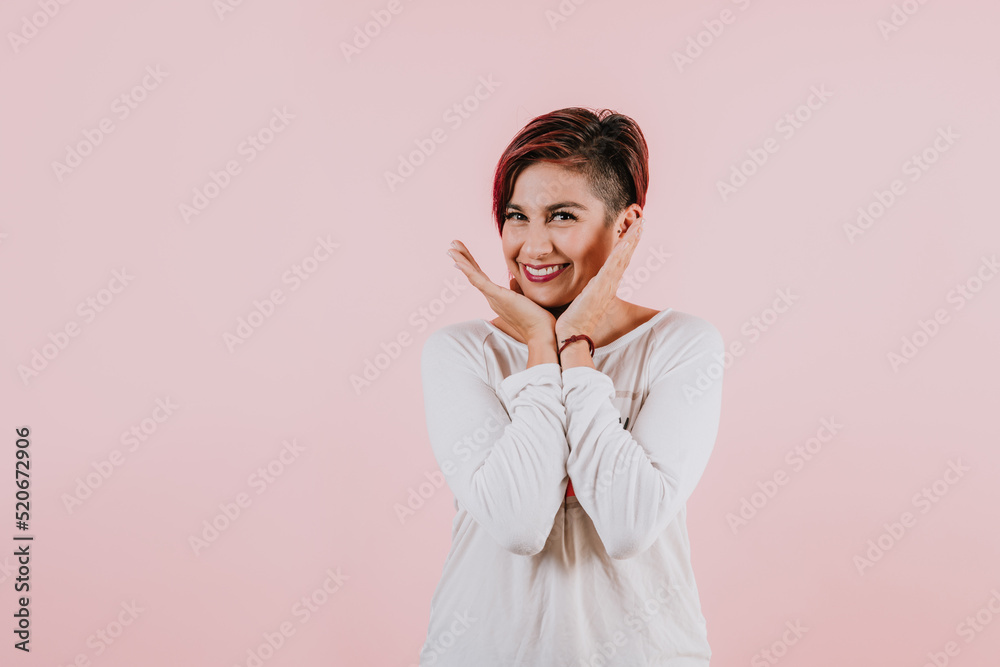 portrait of young hispanic girl posing on coral pink background in Mexico Latin America