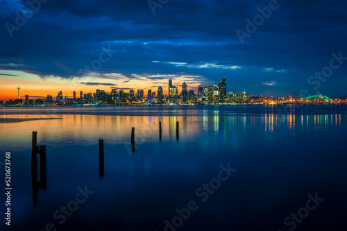 Seattle Skyline During the Morning Blue Hour Seen From West Seattle. Dynamic view of the Seattle cityscape just before dawn with Elliott Bay in the foreground and the waterfront in the distance. 
