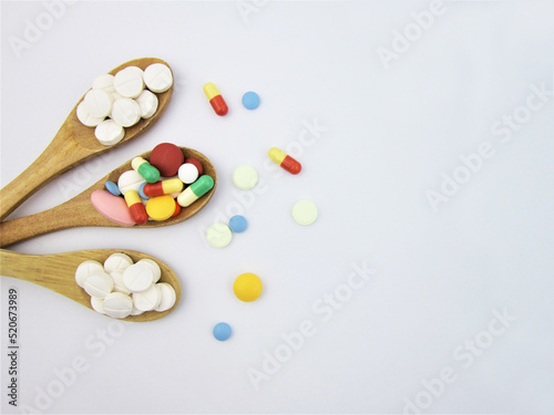     Various pharmaceutical medicine pills, tablets and capsules on wooden spoon                     