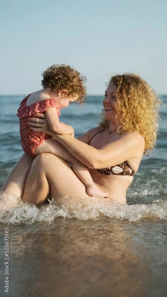a mother playing with her daughter at the beach at sunset a mother playing with her daughter at the beach at sunset