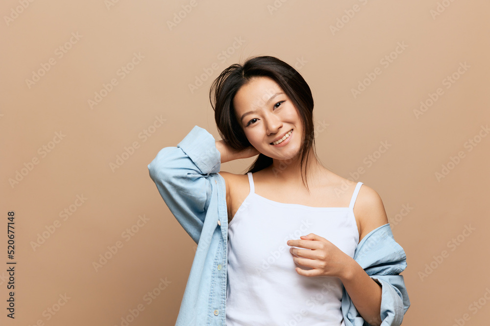 Lovely enjoyed pretty tanned adorable young Asian lady smiling at camera posing isolated on beige pastel background. People and Emotions concept. Copy Space Offer Banner Lovely enjoyed pretty tanned adorable young Asian lady smiling at camera posing isolated on beige pastel background. People and Emotions concept. Copy Space Offer Banner