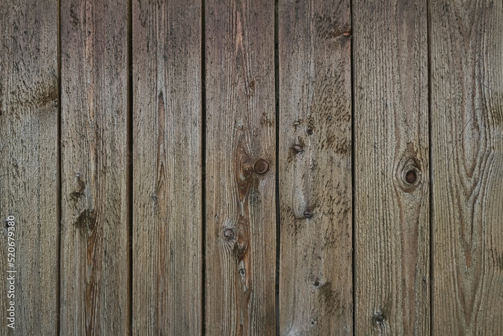 Old grey weathered outside wall of rustic barn covered with vertical worn wooden planks for texture or background. Old grey weathered outside wall of rustic barn covered with vertical worn wooden planks for texture or background.