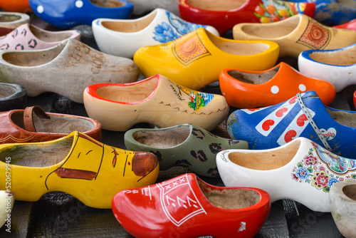 Koog aan de Zaan, Netherlands. July 2022. Colorful clogs against the background of a wooden wall. Popular souvenirs. Traditions of Holland.