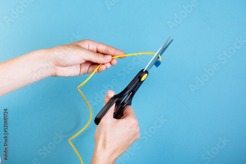 Destroy optical fiber with scissors. Isolated on blue photo