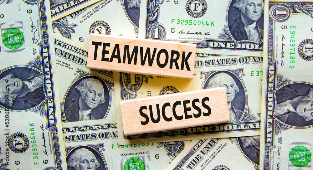 Teamwork success symbol. Concept words Teamwork success on wooden blocks on a beautiful background from dollar bills. Business and teamwork success concept. Copy space.