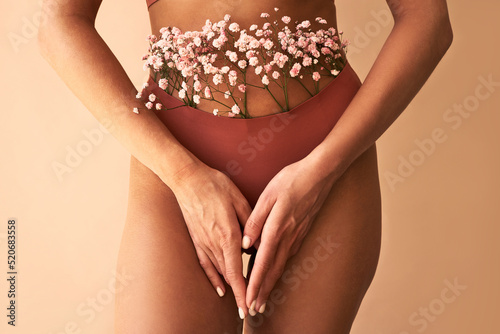   Cropped image of woman in lingerie with flowers made of panties.Women's health and care.
