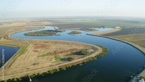 Descending aerial of San Joaquin River surrounded by farmlands in California