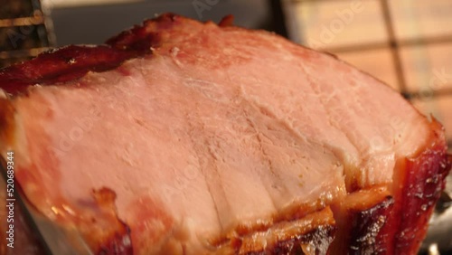 Delicious piece of ham is cut with a knife