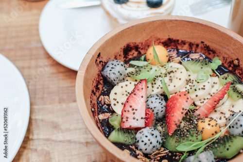 Acai smoothie bowls with strawberries, banana, blueberries, kiwi fruit and granola. Healthy Breakfast in summer.