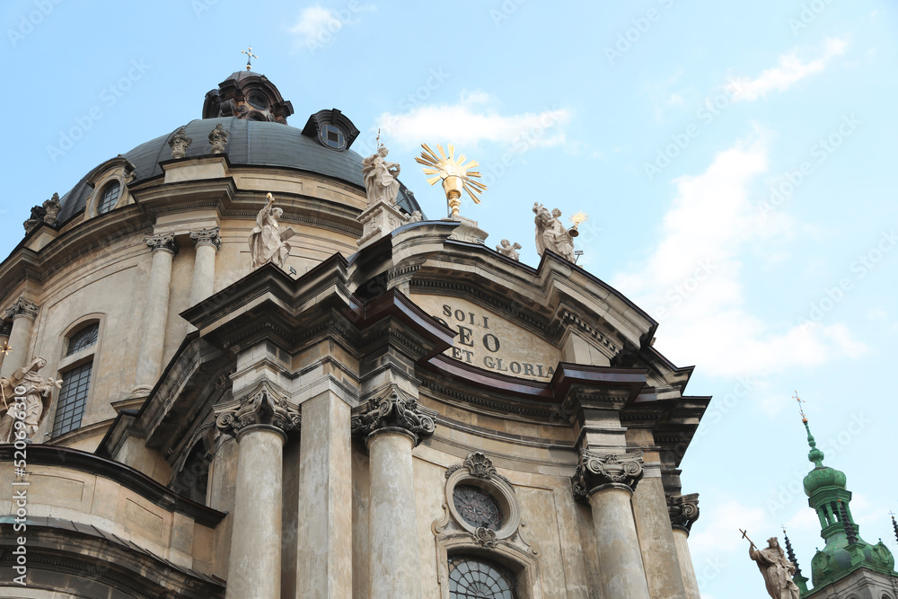 LVIV, UKRAINE - MAY 2, 2022: Beautiful Dominican Cathedral against blue sky, low angle view