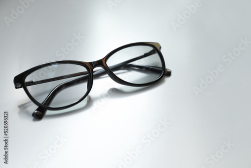 Stylish black eye glasses on white table. Space for text