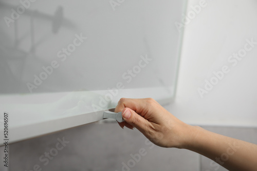 Woman opening cabinet door at home, closeup