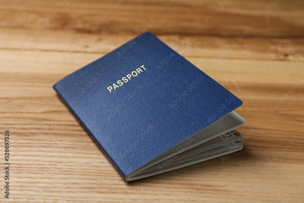 Blank blue passport on wooden table, closeup Blank blue passport on wooden table, closeup