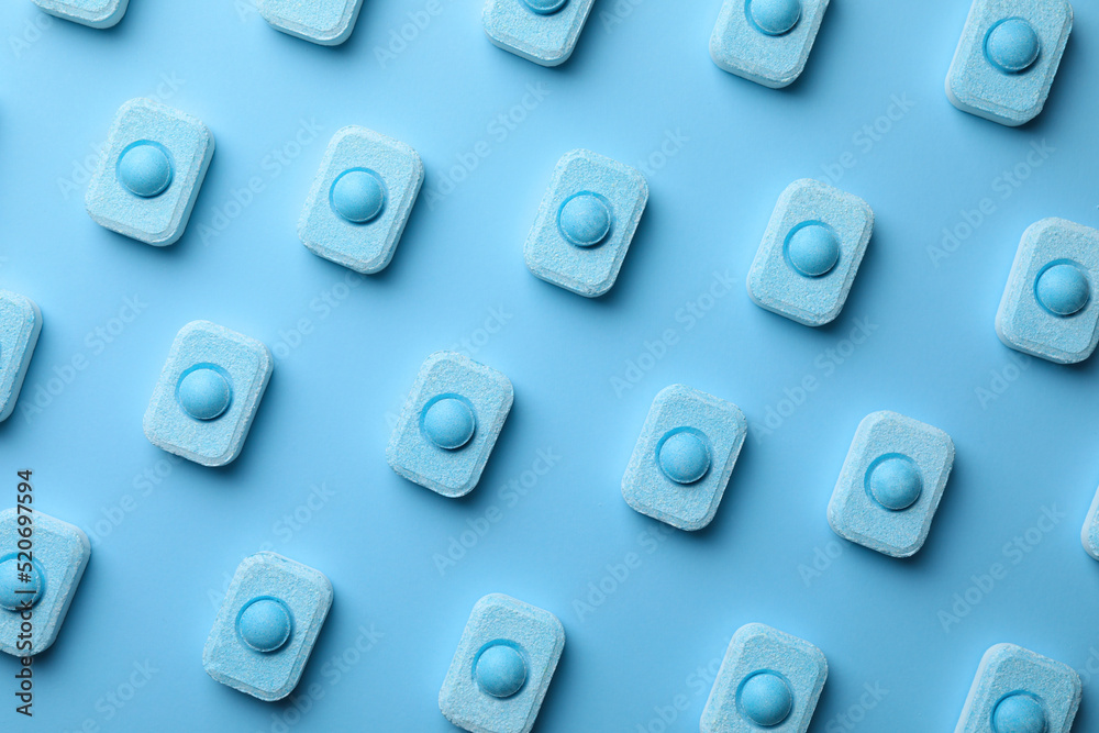 Water softener tablets on light blue background, flat lay Water softener tablets on light blue background, flat lay