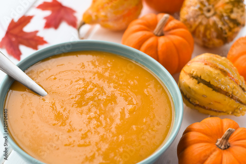 A bowl of pumpkin soup with mini pumpkins