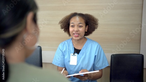 People making an appointment with medical staffs at reception desk in hospital. Medical staff and nurse - receptionist talking to patient in front of the reception counter in hospital.