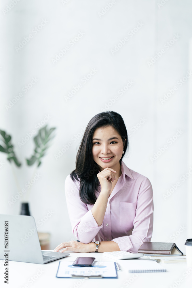Asian business woman using laptop while sitting at home, smiling businesswoman working from home. Asian business woman using laptop while sitting at home, smiling businesswoman working from home.